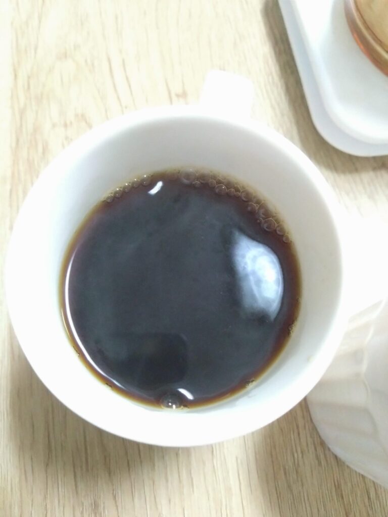 抽出されたコーヒーがマグカップに注がれている様子。透明感のあるコーヒーの色合いが楽しめる完成イメージ。